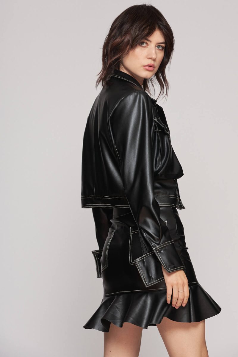 Short ruffle leather skirt and cropped leather jacket creating an edgy two piece set with contrasting white stitches